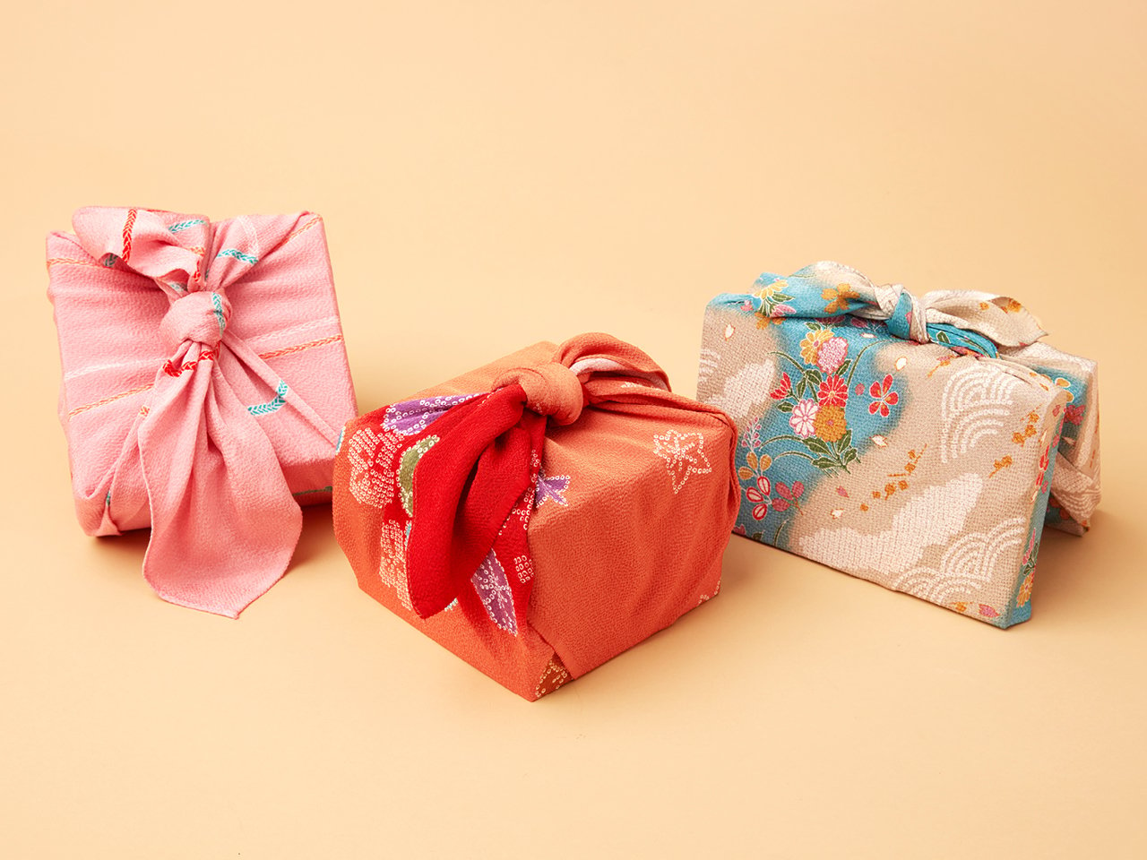 Three rectangular shaped gifts wrapped in cloth