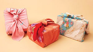 Three rectangular shaped gifts wrapped in cloth