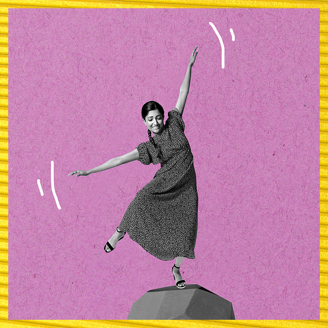A woman playfully balances on a rock.