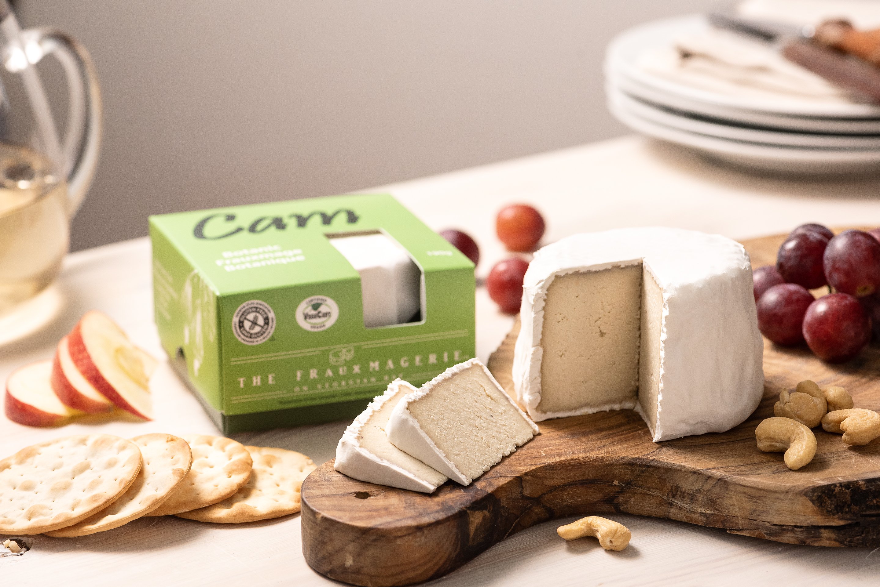 A vegan camembert cheese next to its packaging