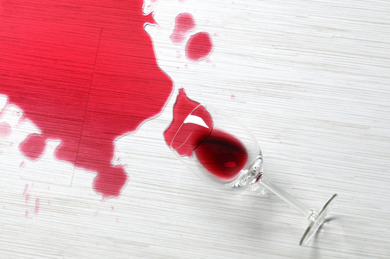 A glass of red wine spilled on the floor