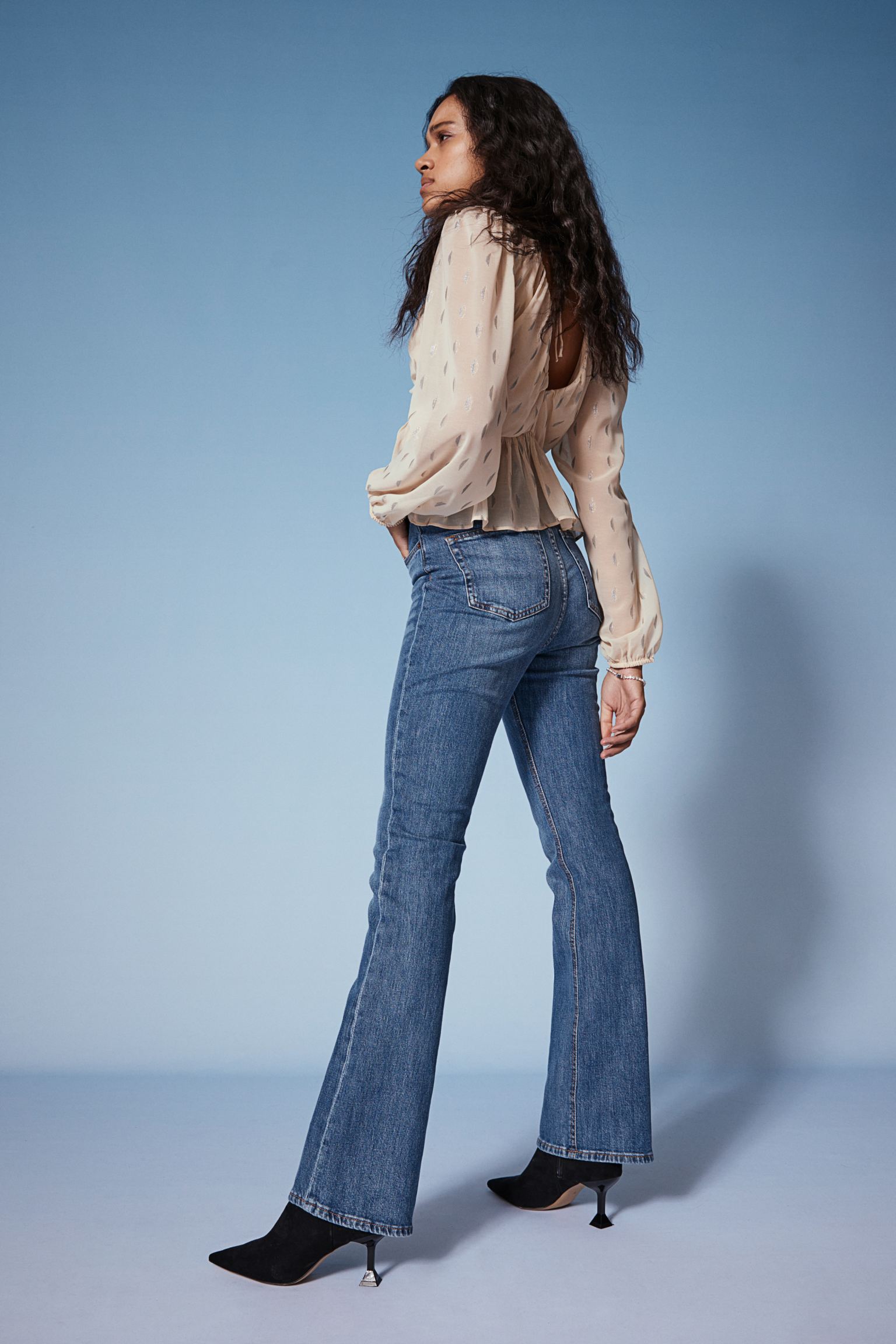 A model wearing a pair of blue flared jeans from H&M