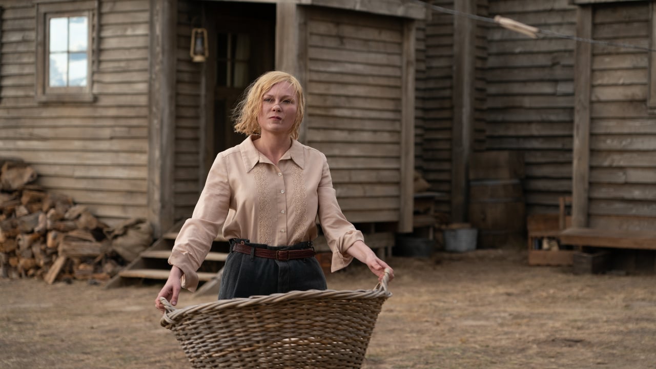 Kirsten Dunst holding a basket outside of a ranch in Montana. Still from the film The Power of the Dog.