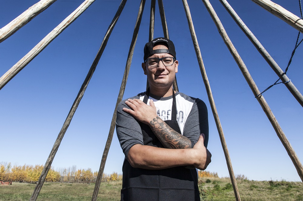 Chef and forager Shane Chartrand posing outdoors for a feature on foraging for spring foods
