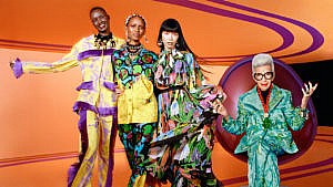 Three models and Iris Apfel dressed in the H&M x Iris Apfel collection against an orange background.