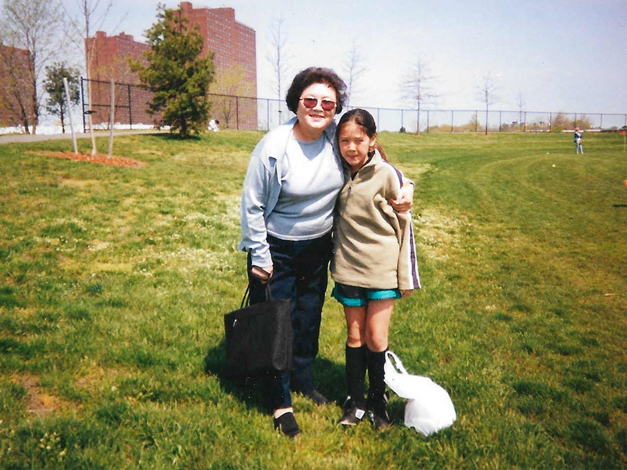 A photo of a young girl posing beside her mother on a field for a feature about learning Korean as an adult