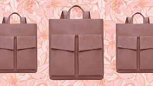 A pink vegan leather laptop bag from Matt & Nat with two front pockets on a pink floral background.