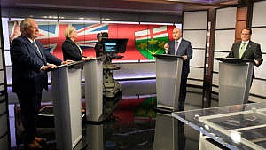 The four Ontario election candidates standing behind podiums.