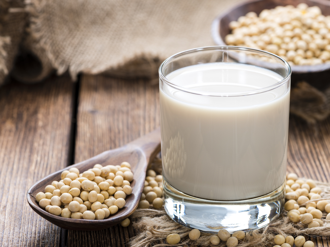 Glass with Soy Milk and Seeds on wooden background