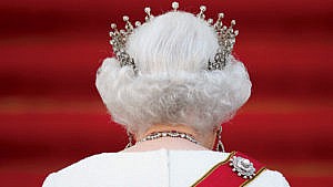A photo of the back of Queen Elizabeth's head, against a red background