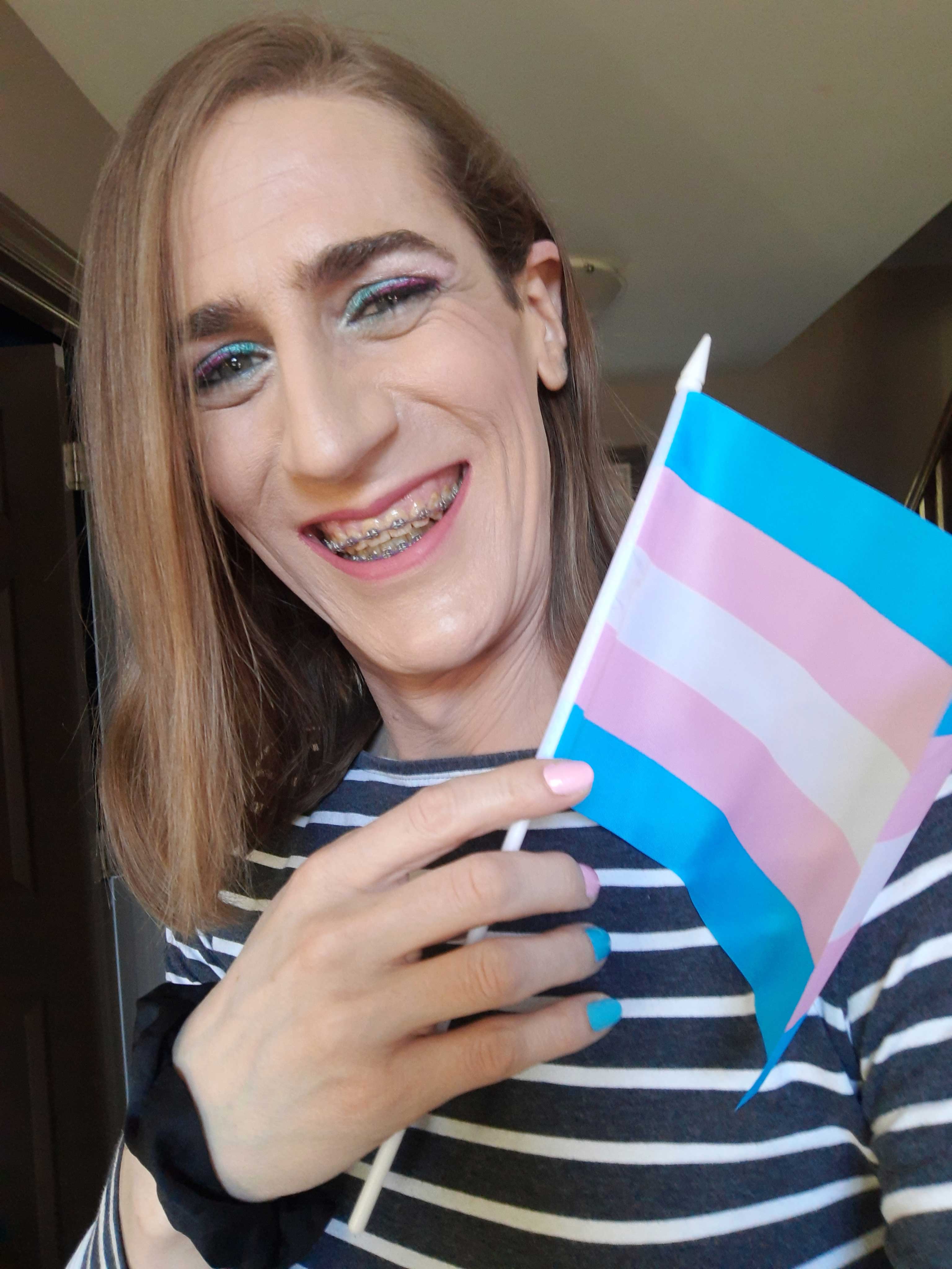 Natalie Moores poses with a trans flag
