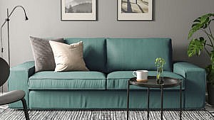 A turquoise Kivik sofa from Ikea in a black and grey living room for a round-up of affordable sofas under $1000.