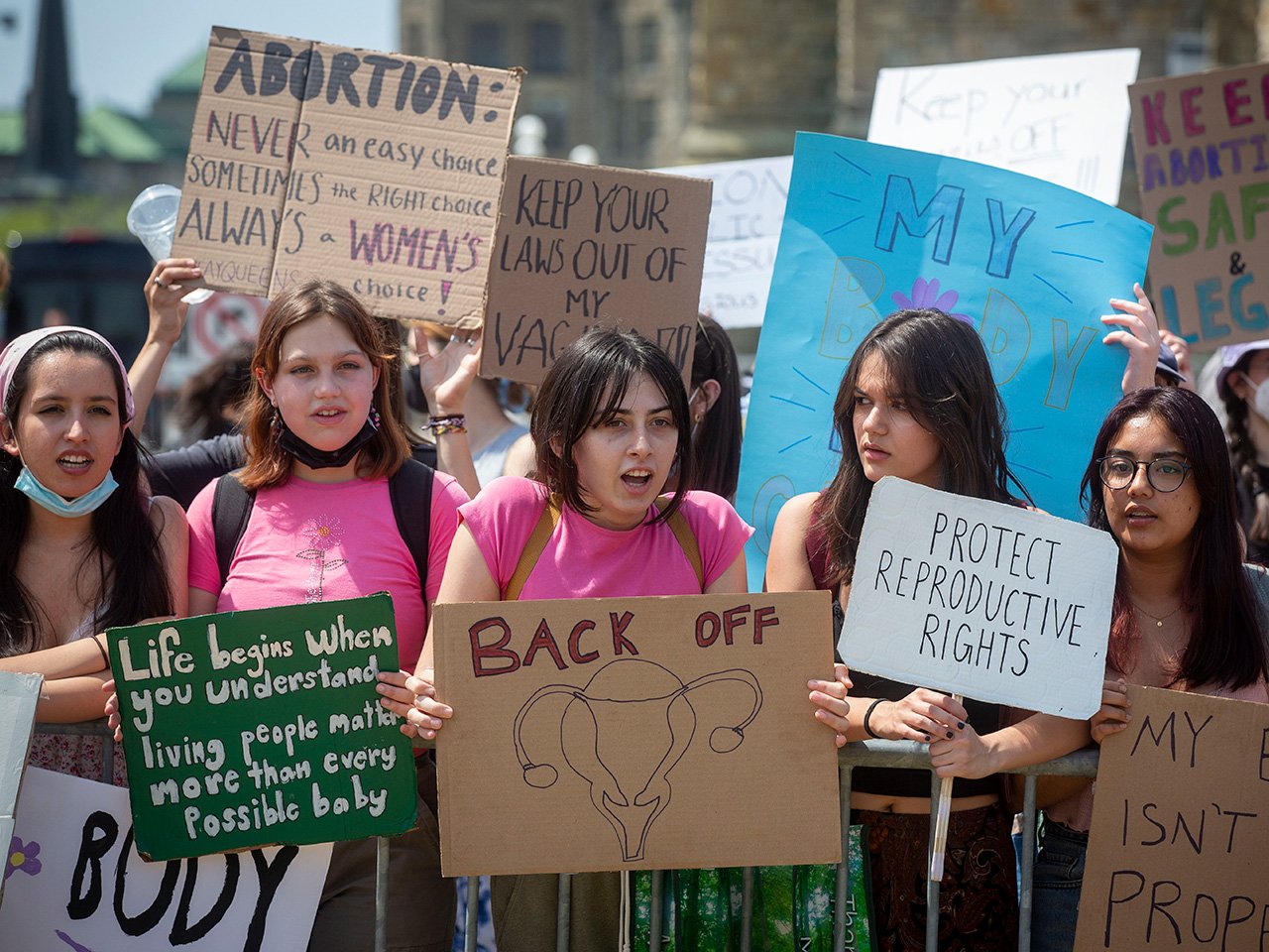 Protesters hold pro-abortion signs on Parliament Hill in Ottawa in May 2022. One month later, Roe v Wade is overturned in the U.S.