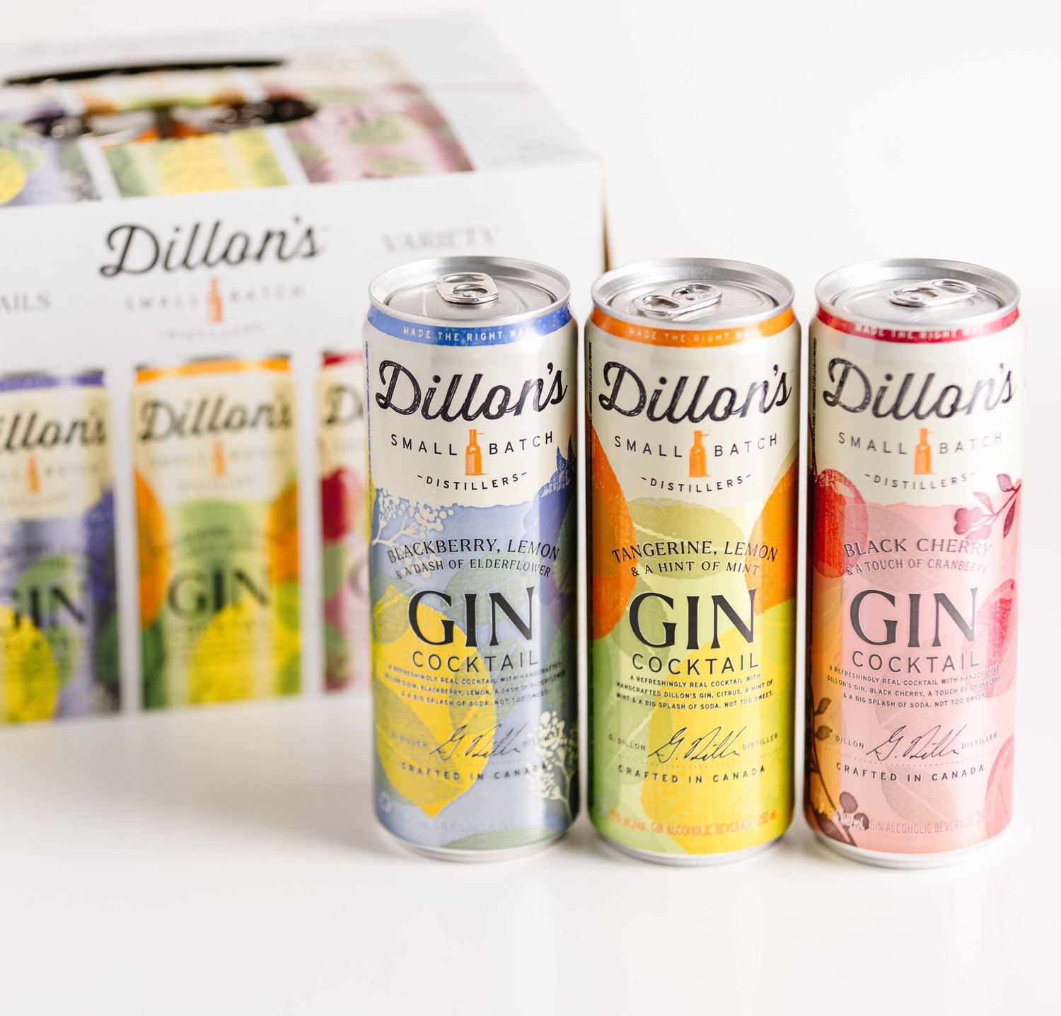 Three cans of Dillon's Gin cocktails in three flavours against a variety box of the canned drinks