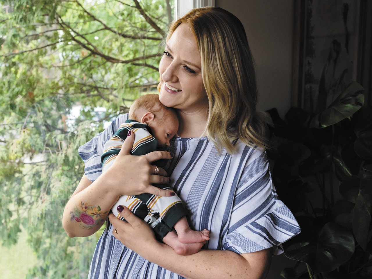Emilee Rausch cradles baby Simon at their Saskatoon home. Simon was conceived with the help of a donor sourced on a Facebook group that connects Canadians hoping to become parents with sperm donors.