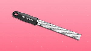Microplane grater on pink background.