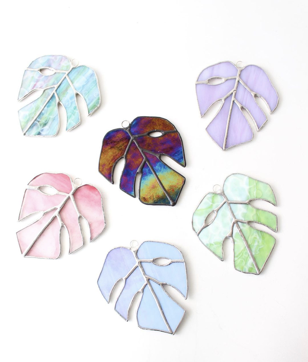 Multicoloured monstera leaves made from stained glass by Canadian maker Sweetfern Studios.