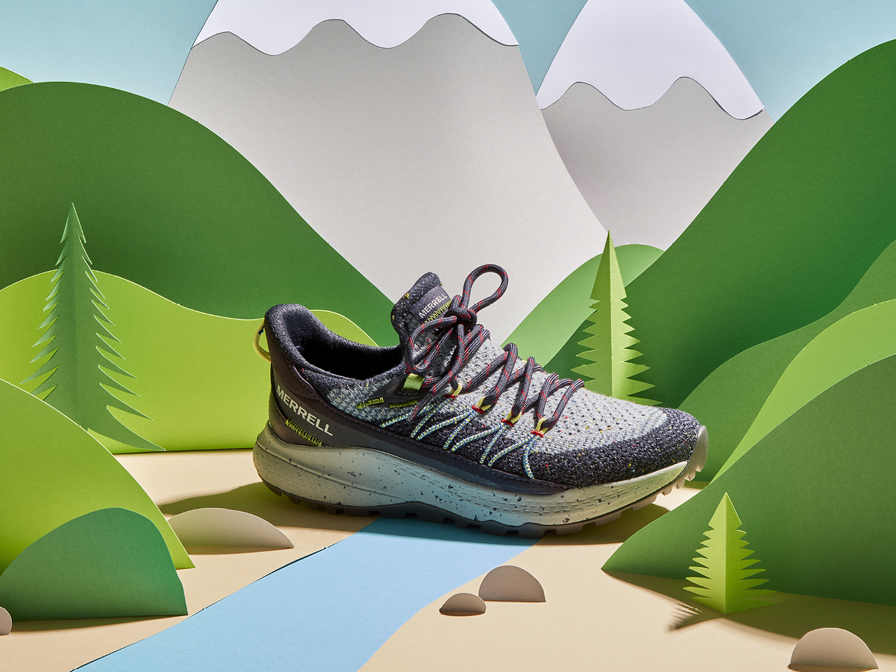 A photo of a grey hiking shoe sitting in a paper forest