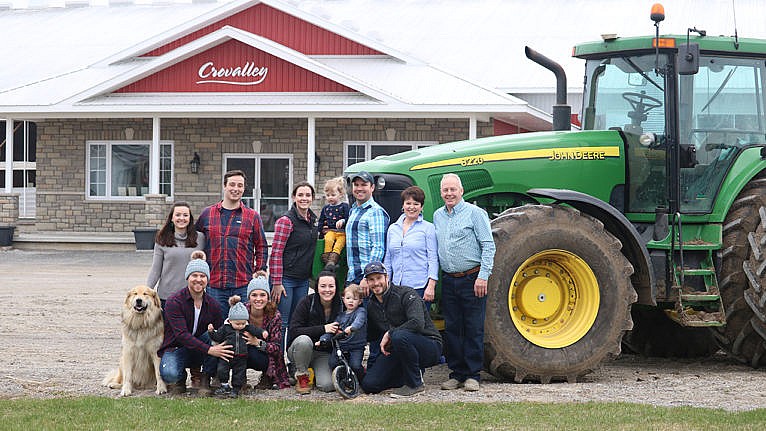 Crowley family posing in front of tractor and Crovalley farm