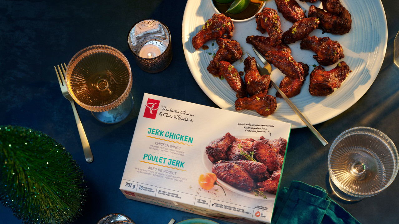 PC Jerk Chicken box next to plate of chicken wings