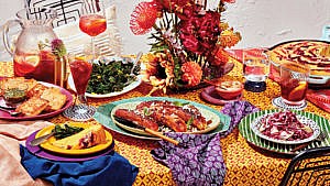 A table with patterned linens set with various dishes made with provision.