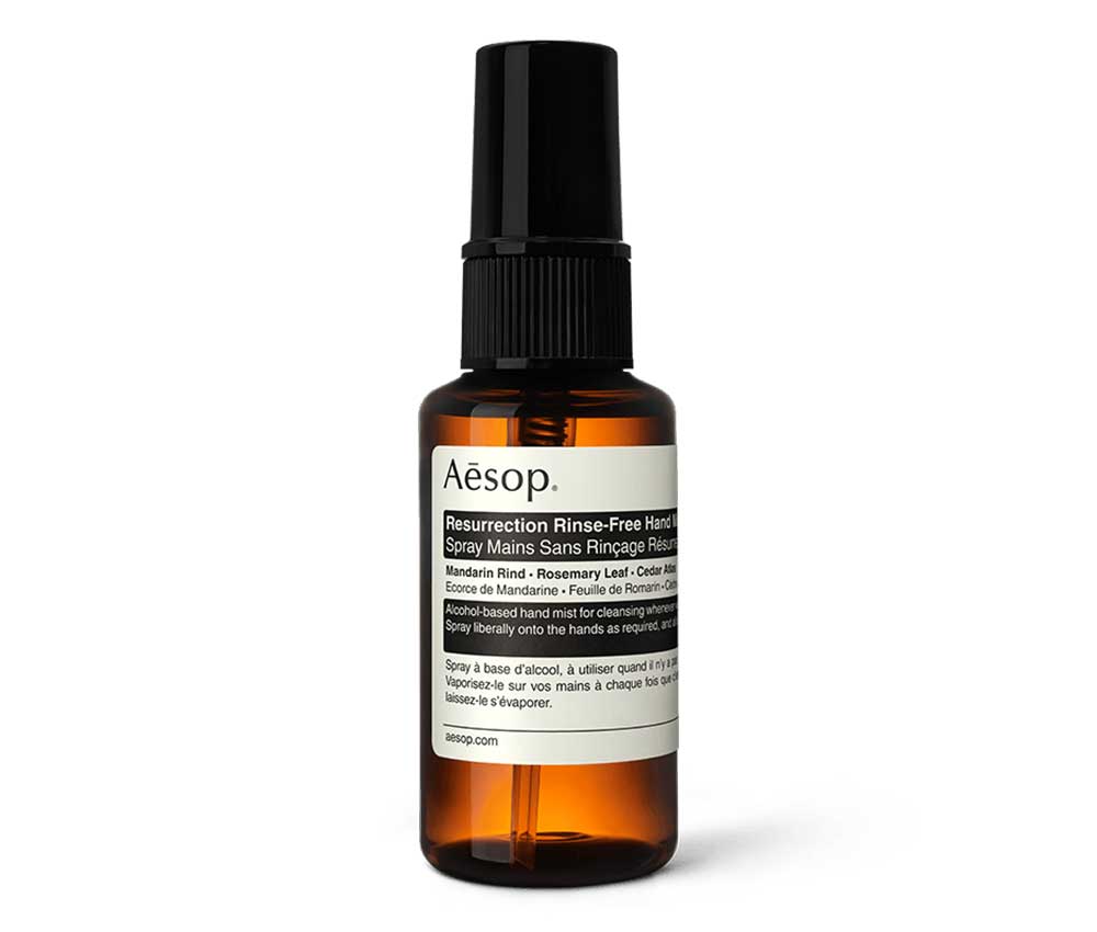 Amber bottle of Aēsop mist hand sanitizer with black and white label.