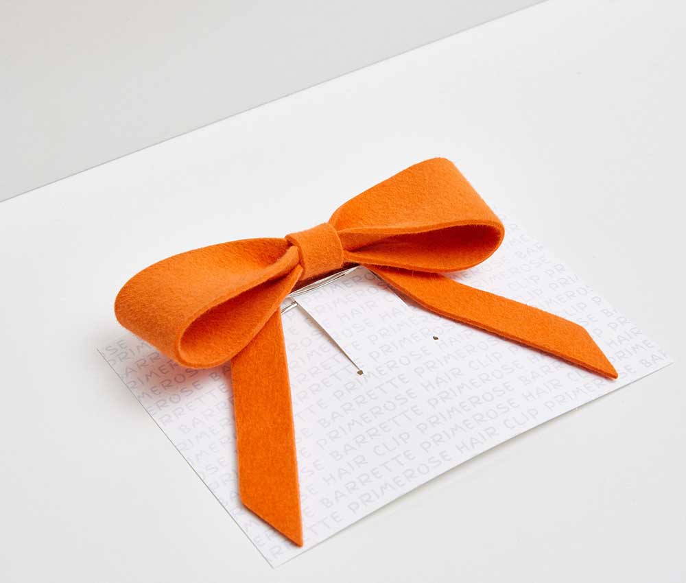 An orange felted hair bow from Heirloom Hats.