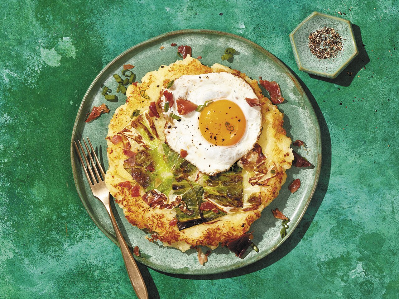 Bubble and squeak—made with leftover steamed cabbage and mashed potatoes—served on a plate with a fried egg