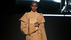 A model dressed in cozy winter trend hue Caramel walking the Michael Kors AW22 runway.