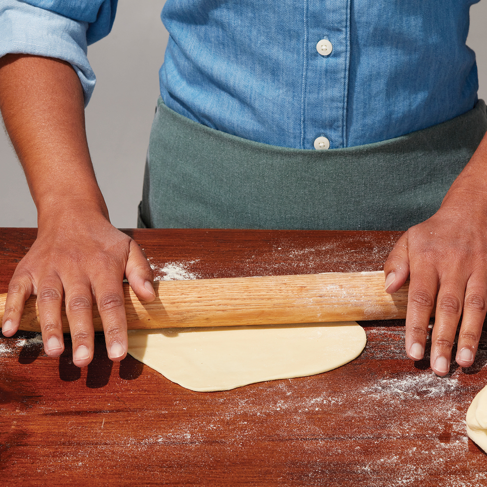 Busiate pasta dough being rolled out with a rolling pin