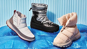 Three pairs of puffer winter boots photographed on a blue bubble wrap background.