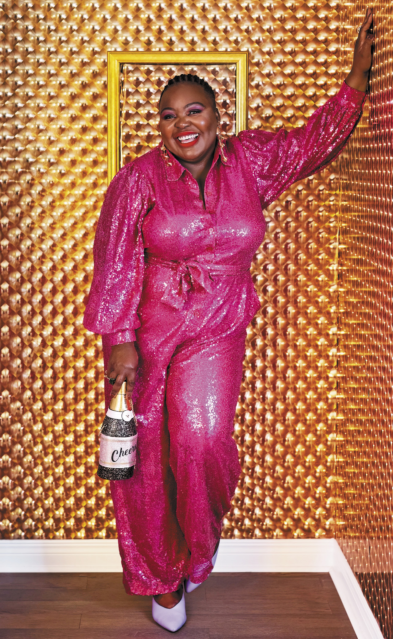 Milaine Astride wearing a sparkly pink jumpsuit for a piece on personal style this holiday season.